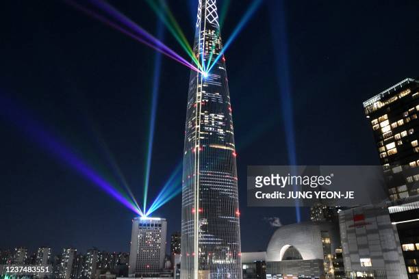 Beam lights are projected from the 123-storey Lotte World Tower skyscraper during a countdown lighting show to celebrate the New Year in Seoul on...