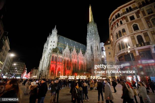 People are seen in front of the Stephansdom Cathedral in the city centre of Vienna, Austria, on New Year's Eve, December 31, 2021. - Due to the...