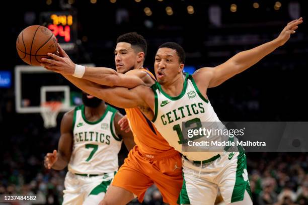 Devin Booker of the Phoenix Suns and Grant Williams of the Boston Celtics fight for possession of the ball during the first half of a game at TD...