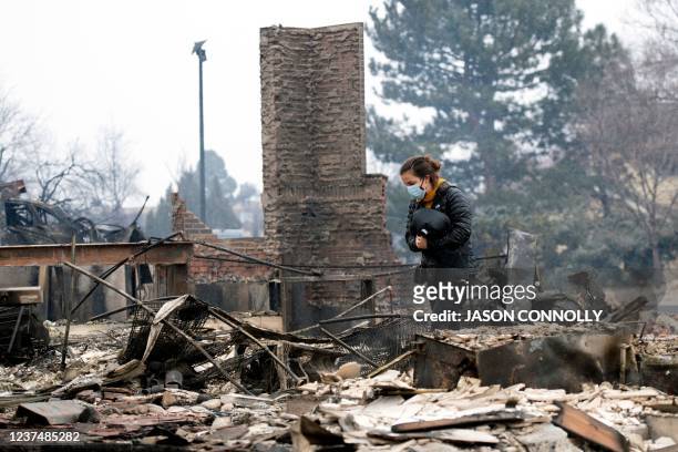 Elise Delaware walks through the remains of her childhood home in The Enclave neighborhood of Louisville, Colorado on December 2021. - A...