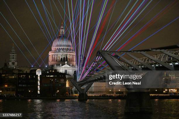Laser show illuminates on the Millennium Bridge as St. Paul's Cathedral is seen in the background during New Year's Eve celebrations on January 1,...