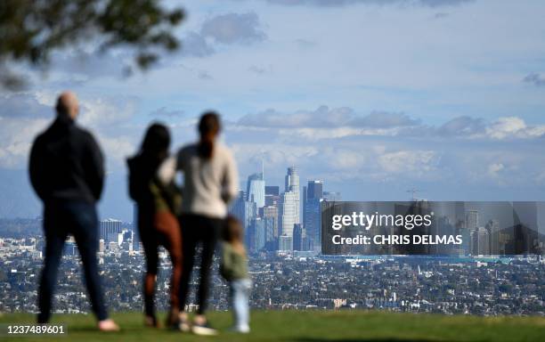 People enjoy the sunny afternoon on New Year's Eve in a Los Angeles park with a view of the downtown skyline, December 31, 2021.