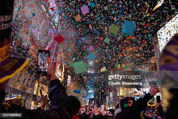 Revellers celebrate as confetti falls during a New Year's Eve celebration in the Times Square area of New York, U.S., on Saturday, Jan. 1, 2022....