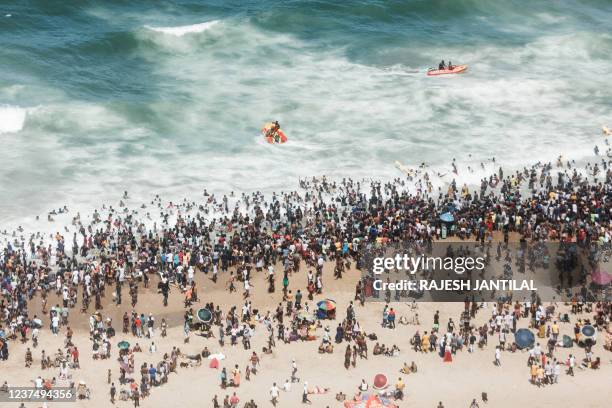 General view taken on January 1, 2022 shows thousands of New Year's day revellers and holidaymakers gathering on the North Pier Beach during New Year...