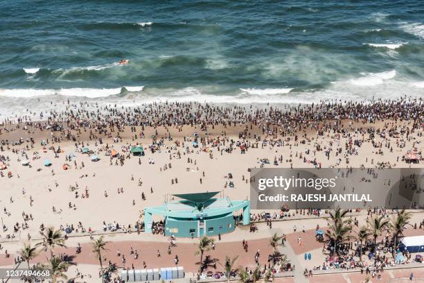 General view taken on January 1, 2022 shows thousands of New Year's day revellers and holidaymakers gathering on the North Pier Beach during New Year...
