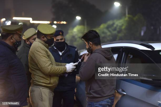 Traffic police personnel uses an alcometer to check a person's blood alcohol content near Sector 18, on December 31, 2021 in Noida, India.