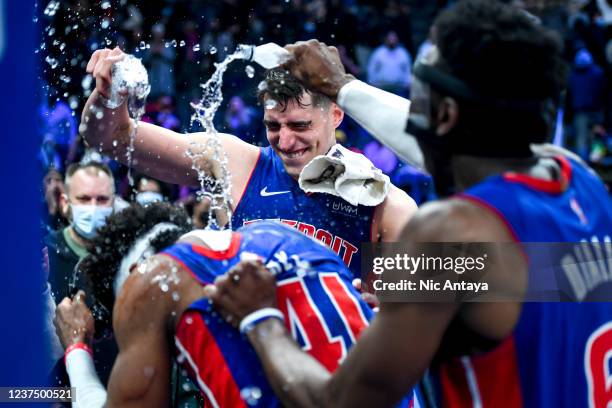 Luka Garza and Hamidou Diallo of the Detroit Pistons pour water on Saddiq Bey while he is interviewed after defeating the San Antonio Spurs at Little...