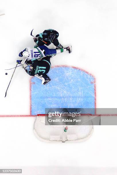 Philipp Grubauer of the Seattle Kraken and Adam Larsson defend against Juho Lammikko of the Vancouver Canucks during the first period at Climate...