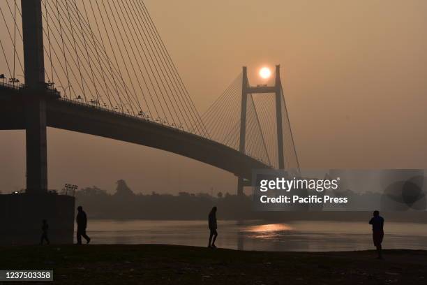 The rising sun amid smog through the Vidyasagar Setu across the Ganges on the first day of Gregorian calendar year 2022.