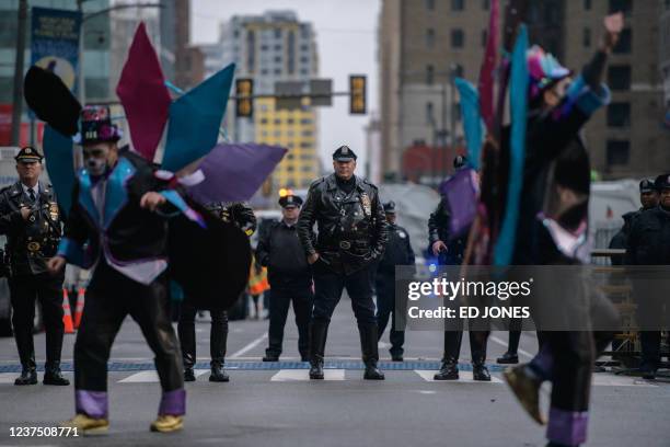 Policeman watches as revellers in fancy dress participate in the annual Mummers Parade in Philadelphia on January 2, 2022. - The Mummers Parade is a...