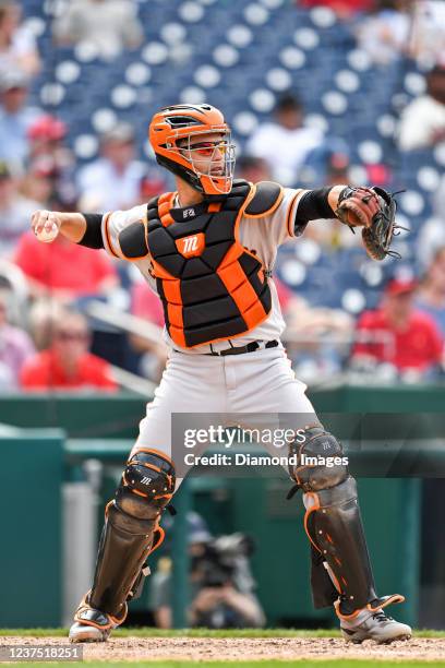 Buster Posey of the San Francisco Giants throws to second base during the sixth inning of game one of a doubleheader against the Washington Nationals...