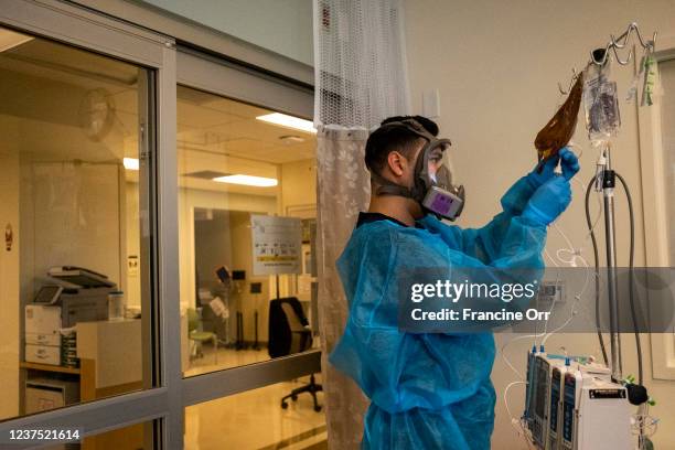 Registered nurse Fernando Fernandez is working inside the ICU in a room with a covid-19 positive patient at at Martin Luther King Jr. Community...