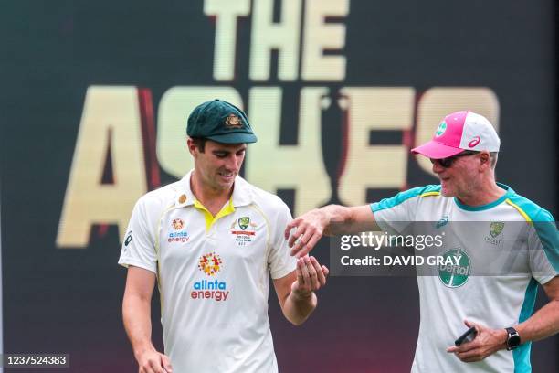 Australia's captain Pat Cummins uses hand sanitizer from a team official during a practice session at the Sydney Cricket Ground on January 4 ahead of...