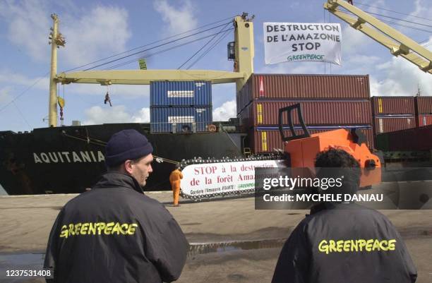 Des militants de Greenpeace manifestent devant le cargo "Aquitania", le 28 juillet 2000 sur le quai de Seine à Honfleur, pour protester contre...