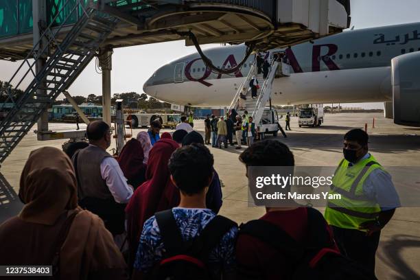 People prepare to board an evacuation flight out of Kabul, Afghanistan, Sunday, Oct. 3, 2021.