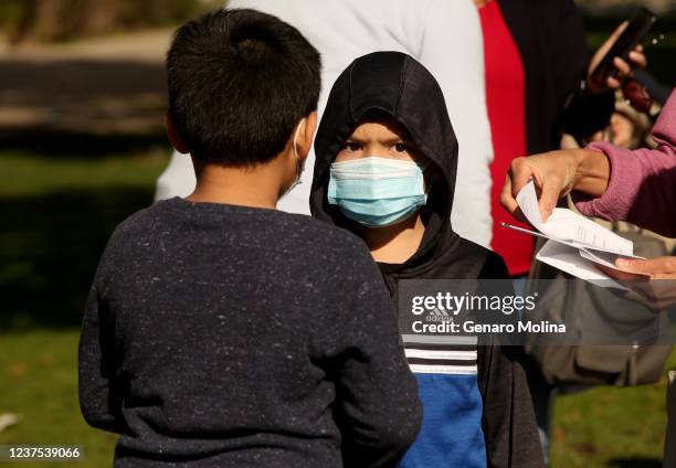 Children join other LAUSD students and staff while waiting in line for a COVID-19 test at a walk-up site at the El Sereno Middle School in the El...