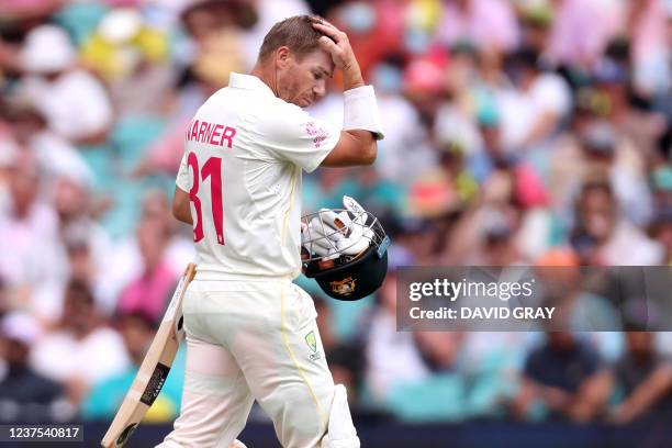 Australia's batsman David Warner walks off the field after his dismissal on day one of the fourth Ashes cricket Test match between Australia and...