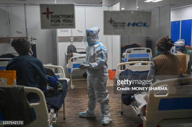 Health worker wearing Personal Protective Equipment suit interacts with patients inside a ward at the Commonwealth games village sports complex,...