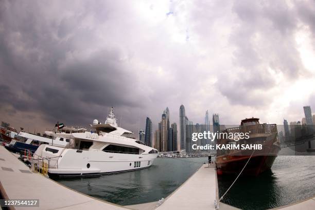 Picture taken with a fisheye lens on January 5, 2022 shows boats and cruise ships docked in Dubai's Marina as bad weather hits the affluent Gulf...