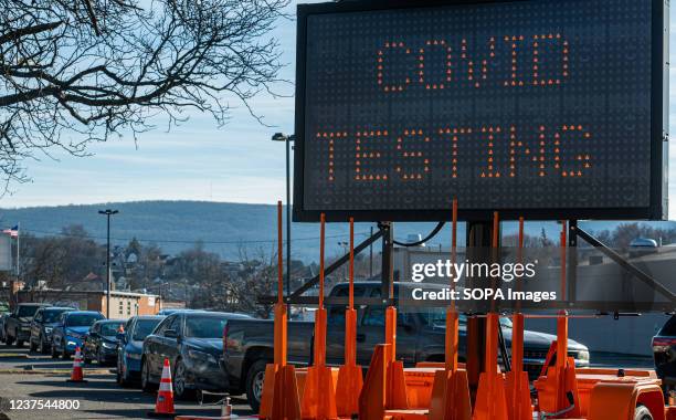 Covid-19 testing billboard is seen at the drive-thru testing site with long queue of cars waiting to get tested in the background. A week long...