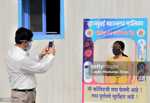 Father clicks a photo of his daughter at selfie point after getting inoculated against Covid-19 during a vaccination drive for teenagers in the 15-18...
