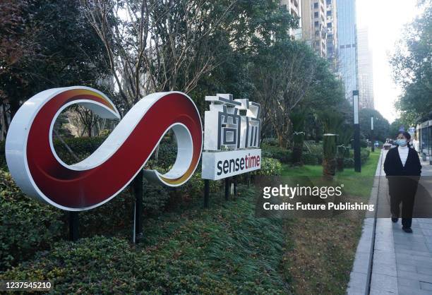 Woman walks by the company signage outside the office building of SenseTime in Hangzhou in Zhejiang province Thursday, Dec. 30, 2021. The Chinese AI...
