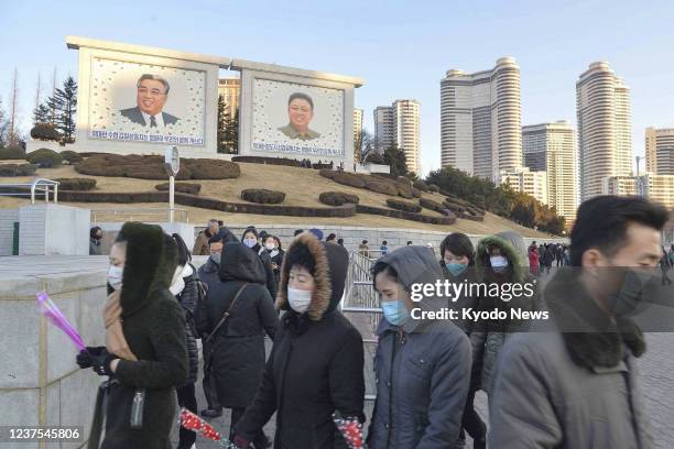 People wearing face masks amid COVID-19 concerns walk in Pyongyang on Dec. 17, 2021.