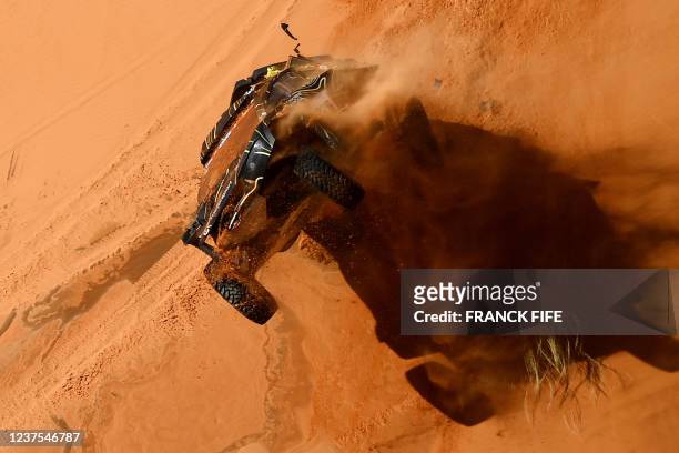 France's driver Guerlain Chicherit and co-driver Alex Winocq crash their buggy during Stage 4 of the Dakar 2022 between al-Qaysumah and Riyadh in...