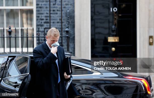 Conservative party chairman Oliver Dowden removes his face covering after arriving by car at 10 Downing Street in central London on January 5, 2022....