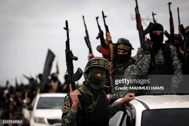 Members of the Palestinian Islamic Jihad movement brandishing their guns, parade through the streets of Gaza City on Januray 5 a day after a member...