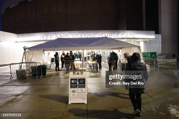 Fans make their way toward the Breslin Center where they have to show proof of vaccination or a negative Coronavirus test to enter prior to a...