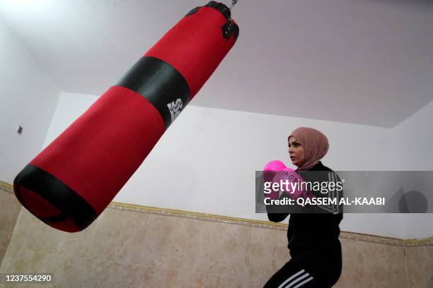 Bushra al-Hajjar, a 35-year-old Iraqi boxing instructor, is pictured during a training session at her home in Najaf on December 14, 2021. - In Iraq's...
