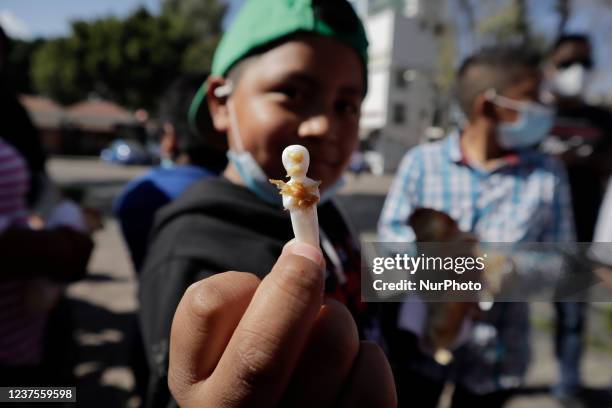 Boy holds a doll that came out of a slice of Rosca de Reyes at the Rotonda de los Personajes Ilustres in Xochimilco, Mexico City, on the occasion of...