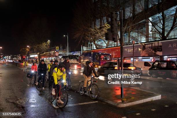 Night scene in Blackfriars of commuter cyclists waiting at the traffic lights on Blackfriars Bridge on 7th December 2021 in London, United Kingdom....