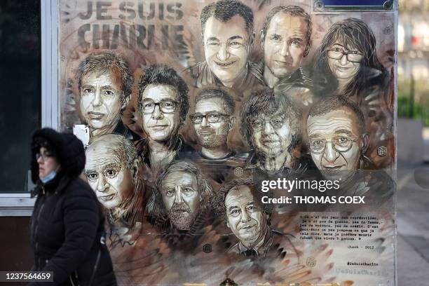 Woman walks past a mural by French street artist and painter Christian Guemy, known as C215 in Paris, on January 6 in tribute to members of Charlie...