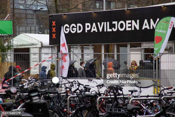 People wearing facemasks wait outside of a GGD Paviljoen Amsterdam Covid-19 testing center facility in line to be tested, GGD is the Municipal Public...