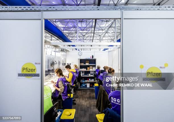 Health workers prepares syringes with doses of the Pfizer/BioNTech Covid-19 vaccine at a vaccination centre set up in Schiphol Sirport in Schiphol,...
