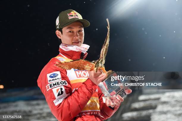 Overall winner Japan's Ryoyu Kobayashi poses with the trophy as he celebrates on the podium after the final round of the Four-Hills FIS Ski Jumping...