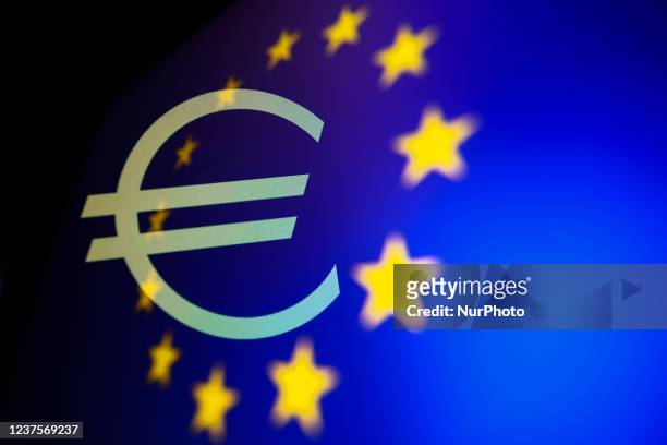 Euro currency symbol displayed on a screen and European Union flag displayed on a screen are seen in this multiple exposure illustration photo taken...