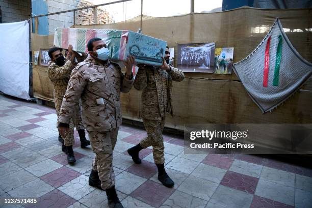 Iranian former Islamic Revolutionary Guard Corps soldiers carry flag-draped coffins of the unknown martyrs during the funeral of 150 Iranians who...