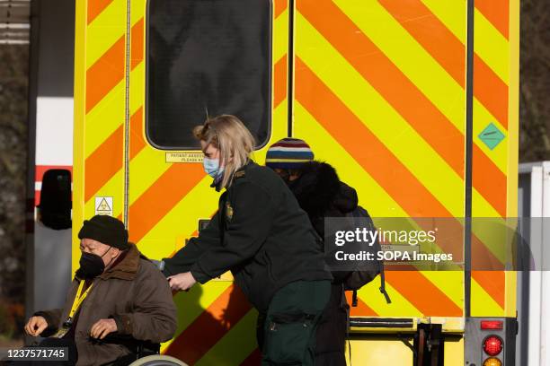 Paramedic seen pushing a wheelchair with a patient from an ambulance to the Accident and Emergency Ward at St Thomas Hospital. NHS Trusts across...