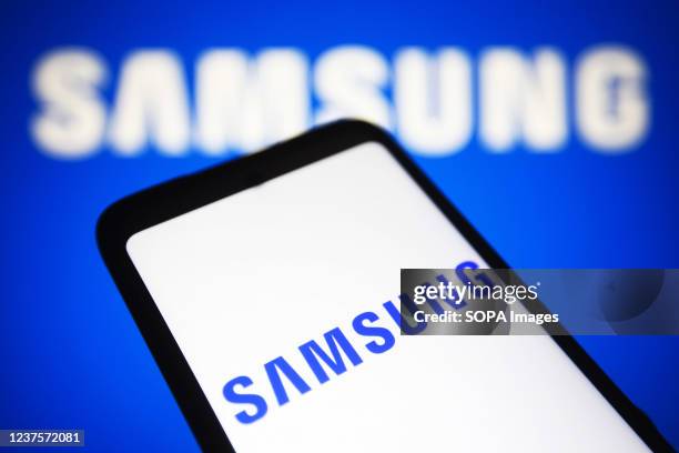 In this photo illustration, Samsung Group logo seen displayed on a smartphone and a computer screen.