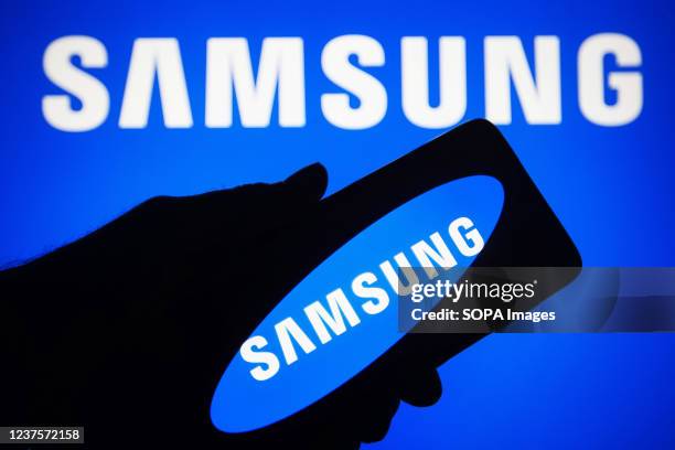 In this photo illustration, Samsung Group logo seen displayed on a smartphone and a computer screen.