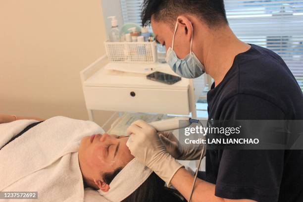 This photo taken on November 5, 2021 shows Yang Kaiyuan , a cosmetic doctor at beauty clinic PhiSkin, performing an operation at the clinic in...