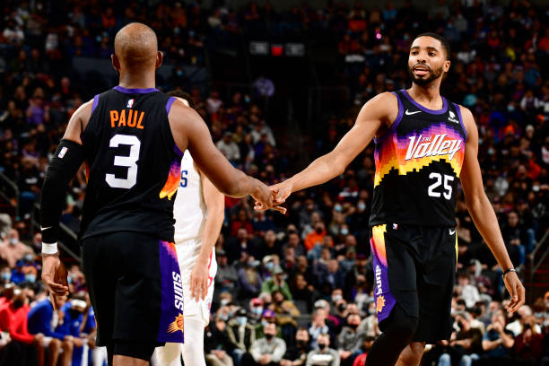 Chris Paul and Mikal Bridges of the Phoenix Suns embrace during the game against the LA Clippers on January 6, 2022 at Footprint Center in Phoenix,...