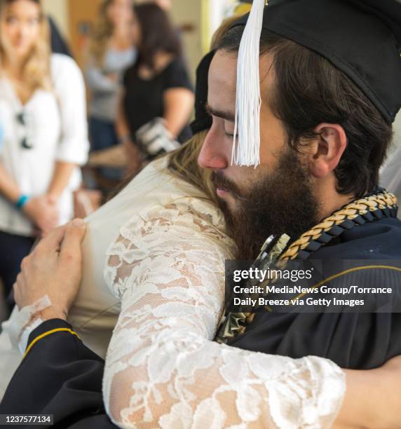 Cory Sullivan, a CSULB psychology major, gets a hug from Christine Tran after he receives his degree at a surprised graduation ceremony and party at...