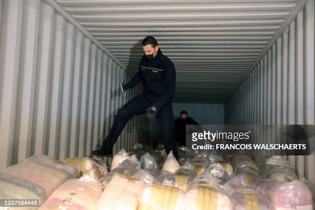 Belgian customs officers search for drugs in a container at Antwerp's port, on January 7, 2022. - The amount of cocaine seized in Europe's key port...