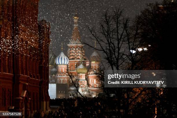 People walk toward the Red Square under light snowfall during the Christmas holidays in Moscow on January 7, 2022. - Orthodox Christians celebrate...