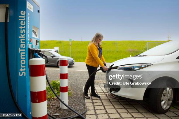 In this photo illustration a woman refuels electricity at a station on May 24, 2021 in Martinszell, Germany.
