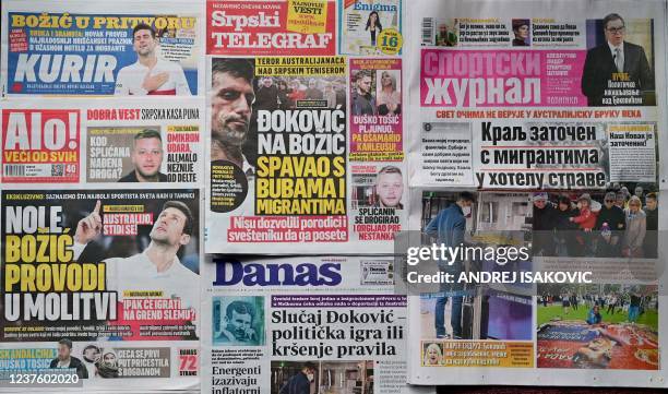 This photograph taken on January 8, 2022 in Belgrade, shows different front pages of Serbian main newspapers with photos and headlines of Serbia's...